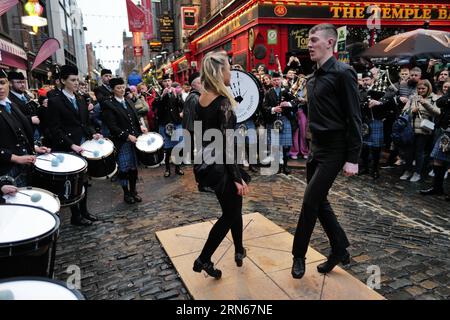 Des danseuses de STEP se produisent pendant le tradfest de Dublin à Temple bar, tandis que des membres du groupe Clew Bay Pipe donnent un coup de main. Temple Bar, Dublin, Irlande Banque D'Images