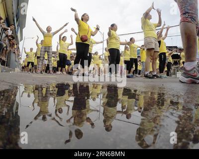 (150719) -- VILLE DE MANDALUYONG, 19 juillet 2015 -- les gens se reflètent sur une flaque d'eau alors qu'ils participent à la tentative officielle de battre le record du monde Guinness pour avoir la plus grande classe de Zumba dans la ville de Mandaluyong, aux Philippines, le 19 juillet 2015. Les Philippines ont établi un nouveau record du monde pour la tenue de la plus grande classe de Zumba au monde avec un total de 12 975 personnes participant à l'événement. ) PHILIPPINES-MANDALUYONG CITY-ZUMBA-RECORD DU MONDE RouellexUmali PUBLICATIONxNOTxINxCHN 150719 Mandaluyong City juillet 19 2015 les célébrités se reflètent SUR une flaque d'eau comme ils participent au O. Banque D'Images