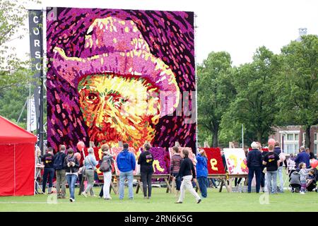 (150730) -- AMSTERDAM, 30 juillet 2015 -- les gens regardent un tableau de fleurs représentant le célèbre peintre néerlandais Vincent van Gogh, au Museumplein à Amsterdam, pays-Bas, le 30 juillet 2015. L'autoportrait de Vincent van Gogh de 8 mètres de haut, composé de 50 000 dahlias, a été construit le 29 juillet pour marquer le 125e anniversaire de sa mort à Auvers-sur-Oise, en France. PAYS-BAS-AMSTERDAM-ART-VINCENT VAN GOGH SylviaxLederer PUBLICATIONxNOTxINxCHN 150730 Amsterdam juillet 30 2015 des célébrités regardent un tableau de fleurs représentant le célèbre peintre néerlandais Vincent van Gogh AU Museumplein à Amst Banque D'Images