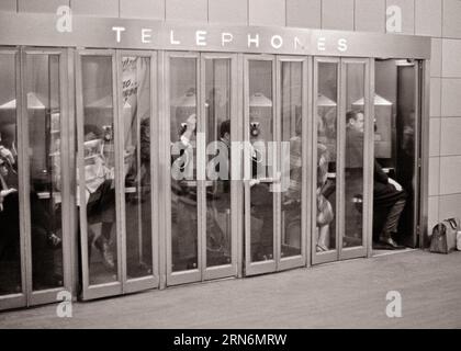 1960S 1970S GROUPE DE SIX CABINES TÉLÉPHONIQUES PUBLIQUES TÉLÉPHONES PAYANTS PLEINS DE NAVETTEURS ANONYMES GRAND CENTRAL STATION NYC NY USA - T6209 HAR001 HARS COPIE ESPACE DAMES PERSONNES ÉTATS-UNIS D'AMÉRIQUE HOMMES SIX NY B&W NAVETTEURS SERVICE À LA CLIENTÈLE PAYER PROGRÈS OPPORTUNITÉ NYC TÉLÉPHONES CONNEXION CONCEPTUELLE NEW YORK TÉLÉPHONES CABINES VILLES GRANDE GARE CENTRALE SOUTENIR NEW YORK VILLE PAYER ANONYME TÉLÉPHONES TÉLÉCOMMUNICATIONS NOIR ET BLANC ETHNICITÉ CAUCASIENNE COMMODITÉ HAR001 OLD FASHIONED Banque D'Images