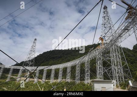 (150802) -- PINGTANG, 2 août 2015 -- la photo prise le 2 août 2015 montre le site d'assemblage du télescope sphérique à ouverture unique FAST à Qiannan, dans la province du Guizhou du sud-ouest de la Chine. L'assemblage des réflecteurs sur le télescope, avec une parabole de la taille de 30 terrains de football et située au fond des montagnes du Guizhou, est entré dans une étape clé alors que les ouvriers ont commencé à hisser le premier réflecteur ici dimanche. Lorsqu'il sera achevé en 2016, le télescope sphérique à cinq cents mètres d'ouverture (FAST) sera le plus grand au monde, dépassant l'observatoire d'Arecibo de Porto Rico, qui mesure 300 mètres de diam Banque D'Images