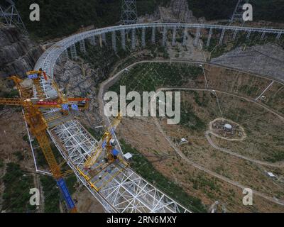 (150802) -- PINGTANG, 2 août 2015 -- une photo prise le 2 août 2015 montre des grues préparées pour le levage du premier réflecteur du télescope sphérique à ouverture unique RAPIDE à Qiannan, dans la province du Guizhou du sud-ouest de la Chine. L'assemblage des réflecteurs sur le télescope, avec une parabole de la taille de 30 terrains de football et située au fond des montagnes du Guizhou, est entré dans une étape clé alors que les ouvriers ont commencé à hisser le premier réflecteur ici dimanche. Lorsqu'il sera achevé en 2016, le télescope sphérique à cinq cents mètres d'ouverture (FAST) sera le plus grand au monde, dépassant l'OB Arecibo de Porto Rico Banque D'Images