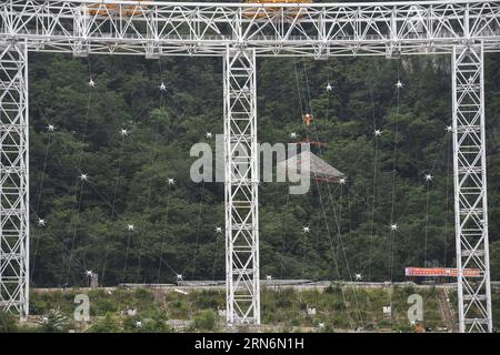 (150802) -- PINGTANG, 2 août 2015 -- la photo prise le 2 août 2015 montre le premier réflecteur du télescope sphérique à ouverture unique en train d'être levé RAPIDEMENT à Qiannan, dans la province du Guizhou du sud-ouest de la Chine. L'assemblage des réflecteurs sur le télescope, avec une parabole de la taille de 30 terrains de football et située au fond des montagnes du Guizhou, est entré dans une étape clé alors que les ouvriers ont commencé à hisser le premier réflecteur ici dimanche. Lorsqu'il sera achevé en 2016, le télescope sphérique à cinq cents mètres d'ouverture (FAST) sera le plus grand au monde, dépassant l'Observatoire d'Arecibo de Porto Rico, qui est de 300 Banque D'Images