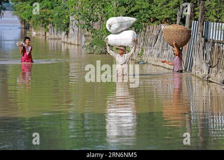 (150803) -- RÉGION DE MAGWAY, 3 août 2015 -- des résidents locaux portent leurs effets personnels alors qu'ils parcourent une zone inondée dans un district de Minbu dans la région de Magway, Myanmar, le 3 août 2015. Les fortes pluies de mousson ont fait au moins 47 morts et en ont affecté plus de 210 000 autres dans 12 des 14 États et régions du Myanmar depuis juin, a déclaré lundi le ministère de la protection sociale, des secours et de la réinstallation. MYANMAR-MAGWAY REGION-INONDATION KyawxZaya PUBLICATIONxNOTxINxCHN 150803 Magway region août 3 2015 les résidents locaux portent leur appartenance comme ils ont molf à travers une zone inondée DANS un district de Magway R. Banque D'Images