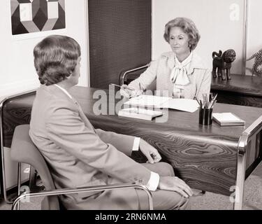 FEMME DES ANNÉES 1970 AU BUREAU PARLANT AVEC UN HOMME VU DE DERRIÈRE PORTANT UN COSTUME D'AFFAIRES - O4106 HAR001 HARS STYLE COMMUNICATION JEUNE ADULTE INFORMATION STYLE DE VIE SATISFACTION FEMMES EMPLOIS MANAGER COPIE ESPACE DEMI-LONGUEUR DAMES PERSONNES HOMMES CADRES B&W COMBINAISON DE COMPÉTENCES ET LE FICHIER TIE INTERVIEWER INTERVIEWER COMPÉTENCES PROFESSIONNELLES HAUT ANGLE DE RÉSEAUTAGE LEADERSHIP VUE ARRIÈRE OPPORTUNITÉ D'AUTORITÉ OCCUPATIONS CONNEXION CONCEPTUELLE DE DERRIÈRE ÉLÉGANT APPLICATION VUE ARRIÈRE GESTIONNAIRES DE COOPÉRATION MI-ADULTE MI-ADULTE FEMME JEUNE ADULTE HOMME NOIR ET BLANC CAUCASIEN ETHNICITÉ HAR001 OLD FASHIONED Banque D'Images