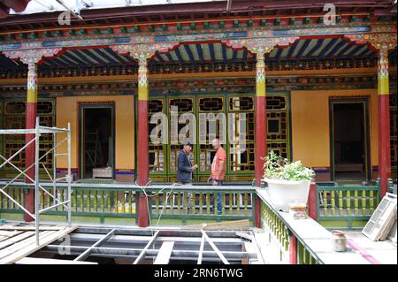 (150807) -- LHASSA, - Lobsang Tashi (à droite) s'entretient avec son employé dans l'un de ses hôtels de style traditionnel tibétain en construction à Lhassa, capitale de la région autonome du Tibet du sud-ouest de la Chine, 5 août 2015. Né dans un village de montagne de la préfecture de Shannan au Tibet, Lobsang Tashi a longtemps nourri un amour profond de la culture traditionnelle du Tibet. Dans sa jeunesse, Lobsang est venu dans la vieille ville de Lhassa et a travaillé comme guide touristique. Poussé par un vif intérêt pour la protection des vieux bâtiments et de la culture de Lhassa, Lobsang Tashi a eu une chance de gagner un droit commercial pour rénover plusieurs vieux bâtiments en Banque D'Images