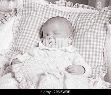 1970S DORMIR BÉBÉ D'UN MOIS DANS LE BERCEAU AVEC LA TÊTE SUR L'OREILLER VICHY - B25666 HAR001 HARS COOPÉRATION CROISSANCE JUVÉNILES RELAXATION BÉBÉ FILLE NOIR ET BLANC ETHNICITÉ CAUCASIENNE HAR001 OLD FASHIONED Banque D'Images