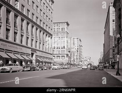 1950s N.W. F STREET SHOPPING DISTRICT WITH JULIUS GARFINCKEL & CO DEPARTMENT STORE AND THE WILLARD HOTEL WASHINGTON DC USA - r3140 HAR001 HARS PROPERTY AND AUTOS DISTRICT OF COLUMBIA EXTERIOR CAPITAL REAL ESTATE F STRUCTURES AUTOMOBILES VEHICLES EDIFICE WILLARD & BLACK AND WHITE DISTRICT FEDERAL HAR001 OLD FASHIONED Stock Photo