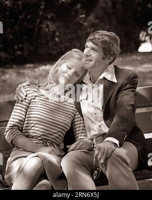 COUPLE ROMANTIQUE DES ANNÉES 1970 ASSIS SUR LE BANC SHADY PARK FEMME APPUYÉE SUR L'ÉPAULE DE L'HOMME SON BRAS AUTOUR DE SES ÉPAULES - R24204 HAR001 HARS LIFESTYLE FEMMES COPIE ESPACE AMITIÉ DEMI-LONGUEUR DAMES PERSONNES SOIGNANT HOMMES CONFIANCE B&W DATANT BONHEUR DOUTEUX JOYEUX SON ATTRACTION RELATIONS SOURIRES CONNEXION COUR AMICALE JOYEUSE ÉLÉGANT HOMME ATTACHEMENT PERSONNEL POSSIBILITÉ AFFECTION COOPÉRATION ÉMOTION MI-ADULTE MI-ADULTE HOMME MI-ADULTE FEMME SOCIAL ACTIVITÉ ENSEMBLE NOIR ET BLANC ETHNICITÉ CAUCASIENNE COURTISANT HAR001 OLD FASHIONED Banque D'Images