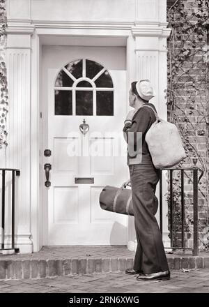 1940s BACK VIEW OF NAVY SAILOR IN UNIFORM HOLDING DUFFLE BAGS STANDING IN FRONT OF THE FRONT DOOR OF HOUSE COMING HOME - m2772 HAR001 HARS WW2 NAVY HOME LIFE UNITED STATES COPY SPACE FULL-LENGTH PERSONS UNITED STATES OF AMERICA MALES FORCE LEAVE B&W NORTH AMERICA COMING FREEDOM NORTH AMERICAN GLOBAL NAVAL EXCITEMENT EXTERIOR POWERFUL WORLD WARS PRIDE WORLD WAR WORLD WAR TWO REAR VIEW WORLD WAR II POLITICS UNIFORMS CONNECTION FORCES CONCEPTUAL FROM BEHIND NAVIES VETERAN WORLD WAR 2 IN FRONT OF VET USN BACK VIEW MID-ADULT MID-ADULT MAN RETURN RETURNING BLACK AND WHITE CAUCASIAN ETHNICITY HAR001 Banque D'Images
