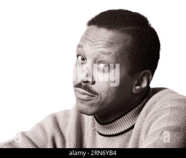 1970s PORTRAIT AFRICAN-AMERICAN MAN WITH MUSTACHE WEARING A MOCK TURTLENECK SWEATER LOOKING AT CAMERA HESITANT FACIAL EXPRESSION - p8102 HAR001 HARS MID-ADULT MAN REALLY AMBIGUOUS BLACK AND WHITE DUBIOUS HAR001 OLD FASHIONED TURTLENECK UNCERTAIN AFRICAN AMERICANS Stock Photo