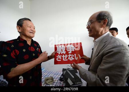 MUDANJIANG, le 11 août 2015 -- le Japonais Yohachi Nakajima (à droite), 73 ans, orphelin de guerre laissé en Chine après la Seconde Guerre mondiale, présente un slogan anti-guerre à son professeur de chinois à Mudanjiang City, dans la province de Heilongjiang, au nord-est de la Chine, le 11 août 2015. Nakajima est allé dans la province du Heilongjiang du nord-est de la Chine en 1942 avec sa famille en tant que membres du groupe des colons japonais alors qu'il n'était qu'un bébé d'un an. Mais en 1945, lorsque le Japon militariste se rendit à la fin de la Seconde Guerre mondiale, il fut laissé en Chine uniquement. Une paysanne chinoise locale a adopté Nakajima, un enfant de l'ancien ennemi. Elle a soigné Banque D'Images