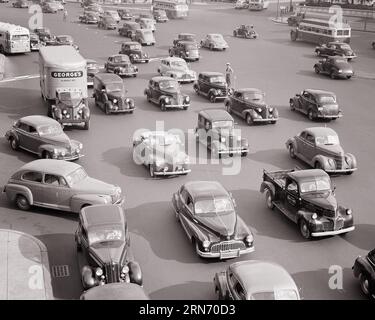 ANNÉES 1940 FUSIONNER LE TRAFIC DE VOITURES SUR UNE LARGE VILLE CAMIONS BUS TRAFIC COP - M3720 HAR001 HARS OLD FASHIONED Banque D'Images