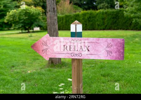 Un panneau disant "relax" sur l'herbe verte. Banque D'Images