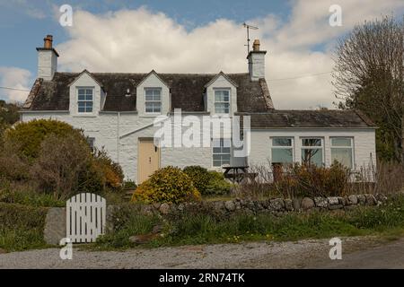 Chalet de pêcheurs peint en blanc au bord de la mer avec une porte d'entrée citron pâle Banque D'Images