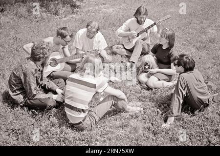 GROUPE DE HIPPIES DES ANNÉES 1960 DE JEUNES ADULTES ET UN CHIEN ASSIS À L'EXTÉRIEUR DANS UN CERCLE JOUANT DES GUITARES - S16178 HARS HARS TRAVAIL D'ÉQUIPE JOIE STYLE DE VIE SON SATISFACTION MUSICIENNE FEMMES COPIE ESPACE AMITIÉ DEMI-LONGUEUR DAMES PERSONNES INSPIRATION PERSONNAGE HOMMES DIVERTISSEMENT HIPPIES DENIM B&W. LIBERTÉ LES GENS HISTOIRE BONHEUR MAMMIFÈRES GRAND ANGLE LOISIRS ET RÉSEAUTAGE CANINES PERSONNAGES SEPT MUSIQUE FOLKLORIQUE OCCASION INSTRUMENT MUSICAL POOCH CONNEXION CONCEPTUEL 7 CHEVEUX LONGS ÉLÉGANT ADOLESCENT JOUANT DE LA GUITARE BLEU JEANS COOPÉRATION CANINE GUITARES MAMMIFÈRE RELAXATION TOGETHERNESS JEUNE HOMME ADULTE Banque D'Images