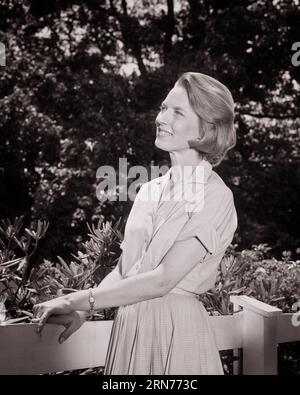 1960S 3/4 PROFIL PORTRAIT DE FEMME SOURIANTE DEBOUT DANS L'ARRIÈRE-COUR PORTANT ROBE SHIRTWAIST REGARDANT VERS LE HAUT - S14751 HAR001 HARS DAMES PERSONNES CONFIANCE RÉFLÉCHIE B&W BONHEUR ÉTÉ COIFFURE JOYEUSE RÉFLÉCHISSANT PENSER FIERTÉ SOURIRES MÉDITER SHIRTWAIST PERDU DANS LA PENSÉE 3/4 PROPRIÉTAIRE JOYEUSE ÉLÉGANCE CONTEMPLATIVE PROPRIÉTÉ D'AIR FRAIS REGARDANT HORS DE CÔTÉ MI-ADULTE MI-ADULTE FEMME SAISON PRINTEMPS SAISON PRINTEMPS PRINTEMPS NOIR ET BLANC ETHNICITÉ CAUCASIENNE CONSIDÉRANT HAR001 VIEUX GARÇON DE PAGE FASHIONED Banque D'Images