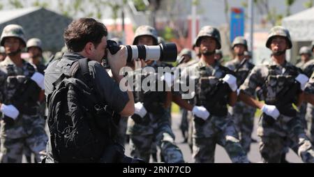 (150822) -- BEIJING, 22 août 2015 -- Un photojournaliste travaille à la base de formation de parades à Beijing, 22 août 2015. Plus de 90 journalistes de plus de 50 médias du pays et de l'étranger ont visité la base d'entraînement du défilé de Beijing où des soldats et des officiers militaires chinois participent à la formation pour le défilé militaire du 3 septembre en commémoration du 70e anniversaire de la fin de la Seconde Guerre mondiale. (wf) CHINA-BEIJING-V-DAY PARADE-PREPARATION (CN) YinxGang PUBLICATIONxNOTxINxCHN 150822 Beijing août 22 2015 un photojournaliste travaille À la base de formation Parade à Beijing août 22 2015 plus de 90 journalistes d'Ove Banque D'Images