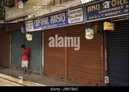 (150902) -- KOLKATA, 2 septembre 2015 -- un garçon indien se tient à côté de magasins fermés lors d'une grève d'une journée à Kolkata, capitale de l'État indien oriental du Bengale occidental, le 2 septembre 2015. La vie normale en Inde a été gravement affectée mercredi par une grève nationale organisée par les syndicats pour protester contre la réforme du droit du travail et la privatisation des secteurs publics par le gouvernement du Premier ministre Narendra Modi. INDIA-KOLKATA-STRIKE TumpaxMondal PUBLICATIONxNOTxINxCHN 150902 Kolkata sept 2 2015 à Indian Boy se tient à côté des magasins fermés lors d'une longue grève d'une journée à Kolkata capitale de l'est de l'État indien OUEST Banque D'Images