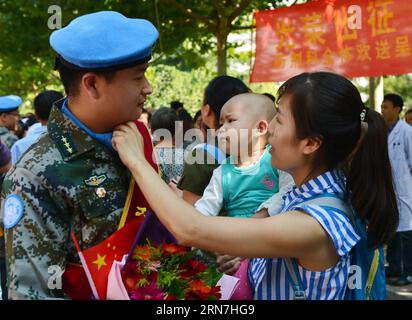 (150908) -- SHIJIAZHUANG, 7 septembre 2015 -- l'épouse de Luo Tao, un membre du personnel médical qui partira pour une mission de maintien de la paix des Nations Unies de 12 mois au Libéria, ajuste les uniformes de son mari à l'hôpital international Bethune Peace à Shijiazhuang, capitale de la province du Hebei du nord de la Chine, le 7 septembre 2015. Ces membres du personnel médical constituent la première équipe du 18e groupe de soldats de la paix chinois envoyés en tournée depuis 2003, lorsque la Chine a rejoint la mission de maintien de la paix au Libéria en vertu de la résolution 1509 du Conseil de sécurité des Nations Unies. La deuxième équipe devrait partir le 17 septembre. Le 18e lot a 508 s. Banque D'Images