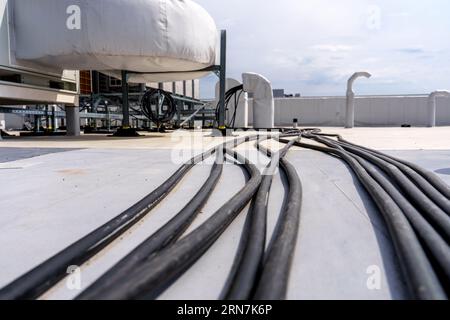 Pose de câbles et de fils sur le toit d'un bâtiment industriel Banque D'Images