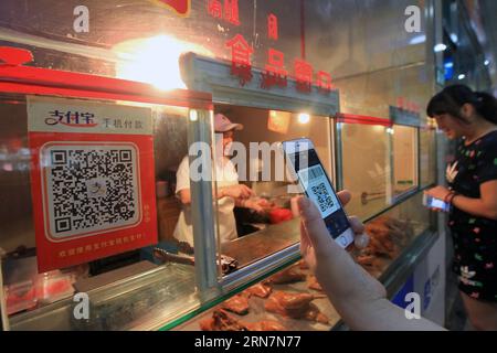 (150914) -- WENZHOU, 14 septembre 2015 -- Une femme scanne le code QR par téléphone portable pour payer ses achats dans un marché de Wenzhou, dans la province du Zhejiang de l'est de la Chine, le 14 septembre 2015. Un marché local a commencé à rendre le service de paiement en ligne Alipay aux clients pour la commodité le lundi. ) (zkr) CHINA-WENZHOU-MARKET-ALIPAY(CN) SuxQiaojiang PUBLICATIONxNOTxINxCHN 150914 Wenzhou sept 14 2015 une femme scanne le QR Code par téléphone portable pour payer ses achats À un marché dans Wenzhou East China S Zhejiang province sept 14 2015 un marché local a commencé à rendre le service de paiement en ligne Alipay aux clients f Banque D'Images