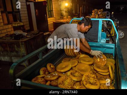 (150923) -- TURPAN, 23 septembre 2015 -- une photo prise le 16 septembre 2015 montre Abduweli Rozi qui se prépare à distribuer du nang, une sorte de pain croustillant, à des vendeurs de son atelier de Turpan, dans la région autonome ouïgour du Xinjiang, au nord-ouest de la Chine. Presque tous les matins, Abduweli Rozi, 45 ans, et sa femme se réveillent avant 3 heures et commencent leur travail. Dans les 10 heures suivantes, ils feraient 300 nang et distribueraient aux vendeurs de la ville. Ce n'est qu'une partie de l'histoire qui a eu lieu tous les jours dans un groupe coopératif de nang Makers à Turpan. Outre la famliy d Abduweli Rozi, 17 familles travaillent ensemble Banque D'Images