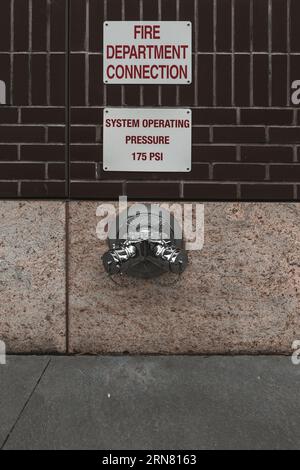 Tuyau d'eau pour bouche d'incendie, monté dans un mur de bâtiment. Manhattan États-Unis Banque D'Images
