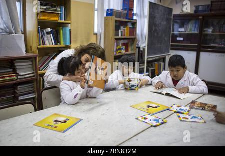 (151003) -- BUENOS AIRES, 3 octobre 2015 -- une image prise le 1 octobre 2015 montre Paula Besteiro (G), enseignante de l'école spéciale n° 1 Alfonsina Storni, en interaction avec un élève lors d'un cours de lecture à la bibliothèque de l'école, à Buenos Aires, Argentine. Paula, qui se consacre à l'éducation depuis 28 ans, est spécialisée dans l'enseignement aux enfants ayant des handicaps mentaux et sociaux. L ' école spéciale Alfonsina Storni, qui compte actuellement 102 enfants, dispense un enseignement de la maternelle au primaire. Martin Zabala) (jp) (vf) ARGENTINA-BUENOS AIRES-SPECIAL SCHOOL-FEATURE e MARTINxZABALA PUBLICATIONxNOTxINx Banque D'Images