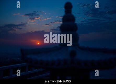 (151009) -- PÉKIN, 9 octobre 2015 -- la photo prise le 27 septembre 2015 montre le lever du soleil au monastère de Longquan à Pékin, capitale de la Chine. Le monastère de Longquan est situé au pied du Fenghuangling (Phoenix Ridge) à la périphérie ouest de Pékin. Construit pour la première fois sous la dynastie Liao (907-1125), le monastère retrouve sa réputation alors qu'il embrasse l'ère de l'Internet mobile. Chaque matin, Maître Xuecheng répond aux questions des internautes sur le compte Weibo équivalent Twitter du monastère de Longquan, qui sera traduit en neuf langues et diffusé. Son WeChat (ou Weixin, service de messagerie instantanée populaire dans Banque D'Images