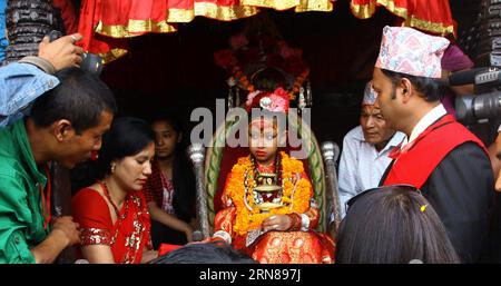 KATMANDOU, le 12 octobre 2015 -- la déesse vivante Kumari (C) observe le festival Bhoto Jatra à Jawalakhel de Lalitpur, Népal, le 12 octobre 2015. Selon la légende hindoue, Rato Machhindranath est un dieu hindou, qui a été amené d'Assam en Inde par un agriculteur dans la vallée de Katmandou au Népal pour éviter une sécheresse pendant la saison du riz. Le festival d'un mois commence avec la construction du char à Pulchowk et se termine avec le festival Bhoto Jatra à Jawalakhel de Patan. Il est célébré par les bouddhistes et les hindous de la communauté Newar en portant le char à différents endroits dans la ville de Patan dans l'espoir Banque D'Images