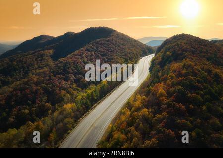 Vue aérienne de l'autoroute I-40 vide en Caroline du Nord menant à Asheville à travers les montagnes des Appalaches pendant la saison d'automne dorée. Crise énergétique et élevé Banque D'Images