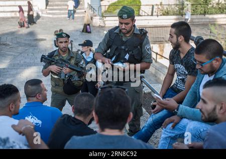 (151016) -- JÉRUSALEM, 16 octobre 2015 -- un garde-frontière israélien vérifie les pièces d'identité des Palestiniens à la porte de Damas dans la vieille ville de Jérusalem, le 16 octobre 2015. Cinq Palestiniens ont été tués vendredi dans les affrontements qui ont éclaté entre les Palestiniens et l'armée israélienne en Cisjordanie et dans la bande de Gaza, selon des sources médicales. Les factions palestiniennes avaient appelé à une journée de rage et à une escalade des manifestations populaires contre l’occupation israélienne en Cisjordanie, à Jérusalem-est et dans la bande de Gaza, parmi les tensions qui entrent dans sa troisième semaine consécutive. MIDEAST-JÉRUSALEM-VIEILLE VILLE-UNRE Banque D'Images