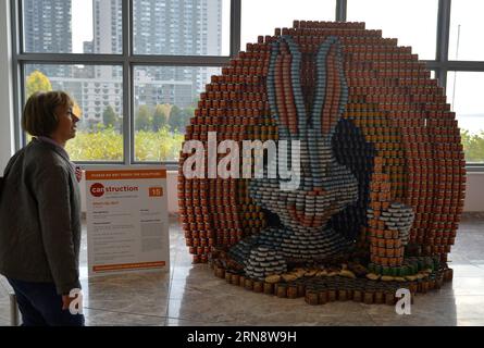 (151106) -- NEW YORK, 6 novembre 2015 -- Une femme regarde une sculpture réalisée à partir de boîtes de conserve lors de la 22e exposition Canconstruction à New York, le 6 novembre 2015. Les œuvres des lauréats du 22e Concours international de design Canconstruction sont exposées au Brookfield place dans le centre-ville de Manhattan. L'exposition présente des sculptures entièrement faites de conserves non ouvertes. Plus de 1 200 lauréats locaux de 125 villes du monde entier ont participé à la compétition. La nourriture en conserve utilisée dans l’exposition sera donnée à une banque alimentaire locale responsable de nourrir plus d’un million de Hungry New Banque D'Images