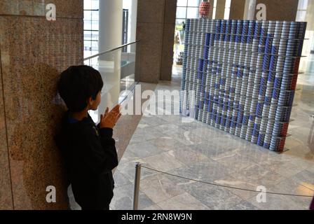 (151106) -- NEW YORK, Nov. 6, 2015 -- A kid watches a sculpture made out of food cans during the 22nd Canstruction exhibition in New York, Nov. 6, 2015. Works by winners of the 22nd Annual Canstruction International Design Competition are displayed in the Brookfield Place in downtown Manhattan. The exhibition features sculptures made entirely of unopened canned food. More than 1,200 local winners from 125 cities around the world participated in the competition. The canned food used in the exhibition will be donated to a local food bank responsible for feeding more than one million hungry New Y Stock Photo