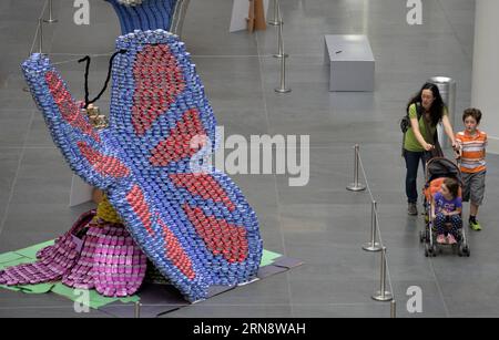 (151106) -- NEW YORK, 6 novembre 2015 -- les gens passent devant une sculpture faite de boîtes de conserve lors de la 22e exposition Canconstruction à New York, le 6 novembre 2015. Les œuvres des lauréats du 22e Concours international de design Canconstruction sont exposées au Brookfield place dans le centre-ville de Manhattan. L'exposition présente des sculptures entièrement faites de conserves non ouvertes. Plus de 1 200 lauréats locaux de 125 villes du monde entier ont participé à la compétition. La nourriture en conserve utilisée dans l’exposition sera donnée à une banque alimentaire locale chargée de nourrir plus d’un million de ne affamés Banque D'Images