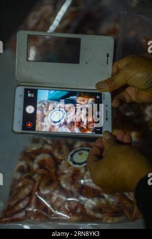 (151111) -- ZHOUSHAN, Nov. 11, 2015 -- Wang Zhifen takes photos of dried shrimps for advertisement on her online shop before the Singles Day Shopping Spree, in Zhoushan, east China s Zhejiang Province. 53-year-old Wang Zhifen was a fisherwoman and she open her online seafood shop last year and became the first e-commerce fishman in the village. China s e-commerce giant Alibaba had recorded sales of 10 billion yuan (1.57 bln U.S. dollars) within 12 minutes and 28 seconds of midnight, smashing records again on this year s Singles Day on Wednesday, China s online buying fiesta akin to America s C Stock Photo