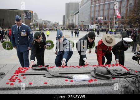 (151111) -- OTTAWA, le 11 nov. 2015 -- les militaires déposent leurs coquelicots sur la tombe du soldat inconnu après la cérémonie annuelle du jour du souvenir au Monument commémoratif de guerre du Canada, à Ottawa, Canada, le 11 novembre 2015. Chaque année, le 11 novembre, les Canadiens reflètent l'honneur de leurs anciens combattants et soldats tombés au combat en portant un coquelicot et en observant une minute de silence à la 11e minute de la 11e heure. ) CANADA-OTTAWA-CÉRÉMONIE DU JOUR DU SOUVENIR DavidxKawai PUBLICATIONxNOTxINxCHN 151111 Ottawa 11 2015 nov. Les hommes et les femmes de service déposent leurs coquelicots SUR la tombe du Soldat inconnu après le rappel annuel Banque D'Images