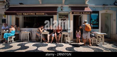 Bar à vins et tapas rue Fredrico Arouca, Cascais, Portugal. Rue Arouca une rue piétonne à Cascais au centre de la vieille ville. La rue pavée bordée de boutiques, restaurants et bars à vin un dimanche après-midi d'été. Banque D'Images