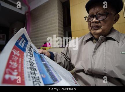 NANJING, le 08 décembre 2015 -- Xiang Yuansong, 87 ans, survivant de l'atroce massacre de Nanjing, lit un journal chez lui à Nanjing, capitale de la province de Jiangsu de l'est de la Chine, le 8 décembre 2015. Xiang Yuansong a survécu au massacre de Nankin quand il avait 9 ans. Son frère aîné Xiang Yuangao, et un de son oncle Xiang Zhonglin ont été tués par l'armée japonaise à Xiaguan de Nankin dans le massacre. Certains survivants du massacre de Nanjing ont organisé des rites commémoratifs familiaux pour leurs proches perdus au Memorial Hall des victimes du massacre de Nanjing par les envahisseurs japonais jeudi, avant la natio Banque D'Images