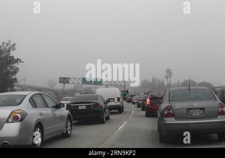 (151210) -- LOS ANGELES, le 10 décembre 2015 -- la circulation traverse un brouillard dense près du centre-ville de Los Angeles, aux États-Unis, le 10 décembre 2015. Les navetteurs sont avertis de conditions de conduite potentiellement dangereuses sur les autoroutes après que le brouillard épais est descendu sur la Californie du Sud. Le National Weather Service dit qu'une inversion marine peu profonde mais forte a conduit à un avis de brouillard dense pour Los Angeles jeudi matin. Les avions qui devaient atterrir à l'aéroport international de Los Angeles pendant la nuit ont été annulés ou retardés à cause du brouillard.) U.S.-LOS ANGELES-FOG ZhaoxHanrong PUBLICATIONxNOTxINxCHN 1512 Banque D'Images