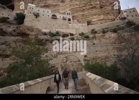 Tourists enjoy the view of the Greek Orthodox St. George monastery in Wadi Qelt, near the West Bank city of Jericho, on Dec. 19, 2015. The sixth-century cliff-hanging complex, with its ancient chapel and gardens, is active and inhabited by Greek Orthodox monks. Wadi Qelt is a valley running west to east across the Judean desert in the West Bank, originating near Jerusalem and terminating near Jericho. Wadi Qelt contains monasteries and old Christian locations. Several aqueducts have been found along the stream, the oldest dating to the Hasmonean period (2nd century BC). Ayman Nobani) MIDEAST-J Stock Photo