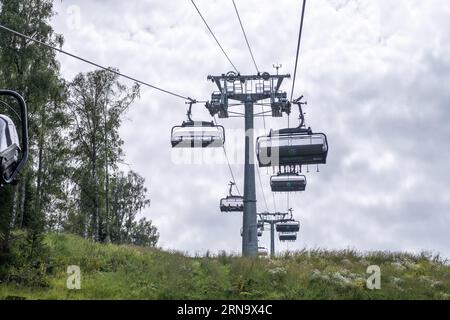 19.08.2023, Manzherok Resort, Russie. Gros plan d'une cabine de télésiège sur le fond des montagnes et des forêts. Voyage en téléphérique vers les points de vue dans le moun Banque D'Images