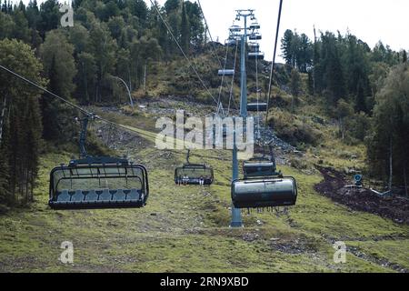 19.08.2023, Manzherok Resort, Russie. Gros plan d'une cabine de télésiège sur le fond des montagnes et des forêts. Voyage en téléphérique vers les points de vue dans le moun Banque D'Images