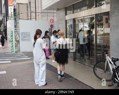 TOKYO, JAPON - 18 août 2023 : les clients attendent à l'extérieur de 'I'm Donut ?', un magasin de beignets populaire dans le quartier de Shibuya à Tokyo. Banque D'Images