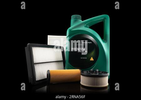 Huile moteur de voiture et filtres isolés sur fond noir. Huile de voiture, air, filtres à carburant et huile de moteur dans la boîte en plastique isolé. Pièces de rechange de qualité pour voiture Banque D'Images