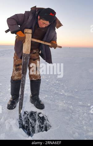 (160109) -- SONGYUAN, le 8 janvier 2016 -- Un pêcheur perce un trou sur de la glace épaisse sur le lac Chagan dans la ville de Songyuan, dans la province de Jilin au nord-est de la Chine, le 8 janvier 2016. Le lac Chagan, qui est connu pour la pêche traditionnelle d'hiver qui remonte à l'époque préhistorique, est le seul endroit qui conserve la plus ancienne méthode de pêche mongole. Pendant le festival annuel de la pêche hivernale qui se tient pour rappeler la vieille tradition de pêche hivernale, les pêcheurs forent d'abord de nombreux trous dans la glace épaisse, puis placent un filet sous la glace, qui sera finalement tiré par un treuil tirant des chevaux. Le lac a établi un Guinnes Banque D'Images