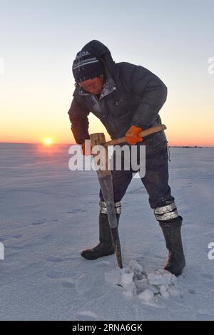 (160109) -- SONGYUAN, le 8 janvier 2016 -- Un pêcheur perce un trou sur de la glace épaisse sur le lac Chagan dans la ville de Songyuan, dans la province de Jilin au nord-est de la Chine, le 8 janvier 2016. Le lac Chagan, qui est connu pour la pêche traditionnelle d'hiver qui remonte à l'époque préhistorique, est le seul endroit qui conserve la plus ancienne méthode de pêche mongole. Pendant le festival annuel de la pêche hivernale qui se tient pour rappeler la vieille tradition de pêche hivernale, les pêcheurs forent d'abord de nombreux trous dans la glace épaisse, puis placent un filet sous la glace, qui sera finalement tiré par un treuil tirant des chevaux. Le lac a établi un Guinnes Banque D'Images