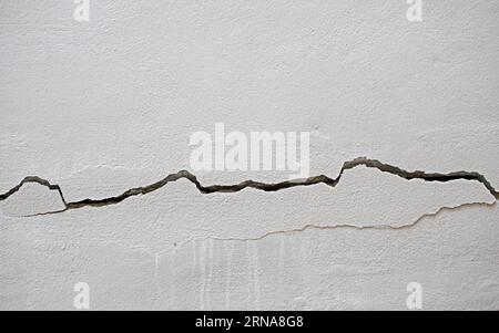Fissures sur le mur de ciment le concept de l'image indique un danger ou un dommage. Banque D'Images