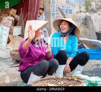 Deux vendeuses de rue discutant à Hai Thanh, un village de pêcheurs le long de la rivière Song Lach Bang dans la province de Thanh Hoa au Vietnam. Banque D'Images